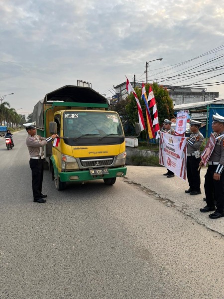 Satlantas Polres Pelalawan Bagikan Bendera Merah Putih di Jalintas Timur Kawasan Lapak Pangker
